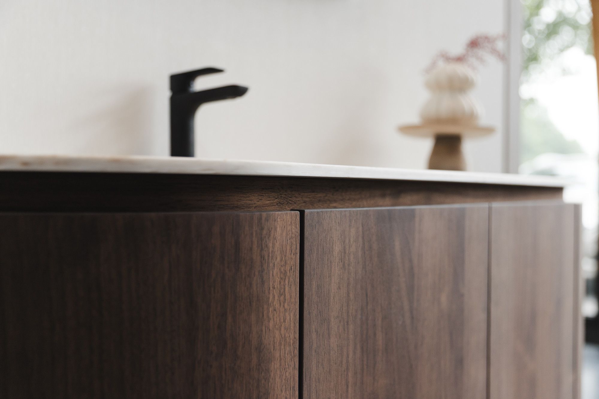 Detail van notenhouten badkamermeubel