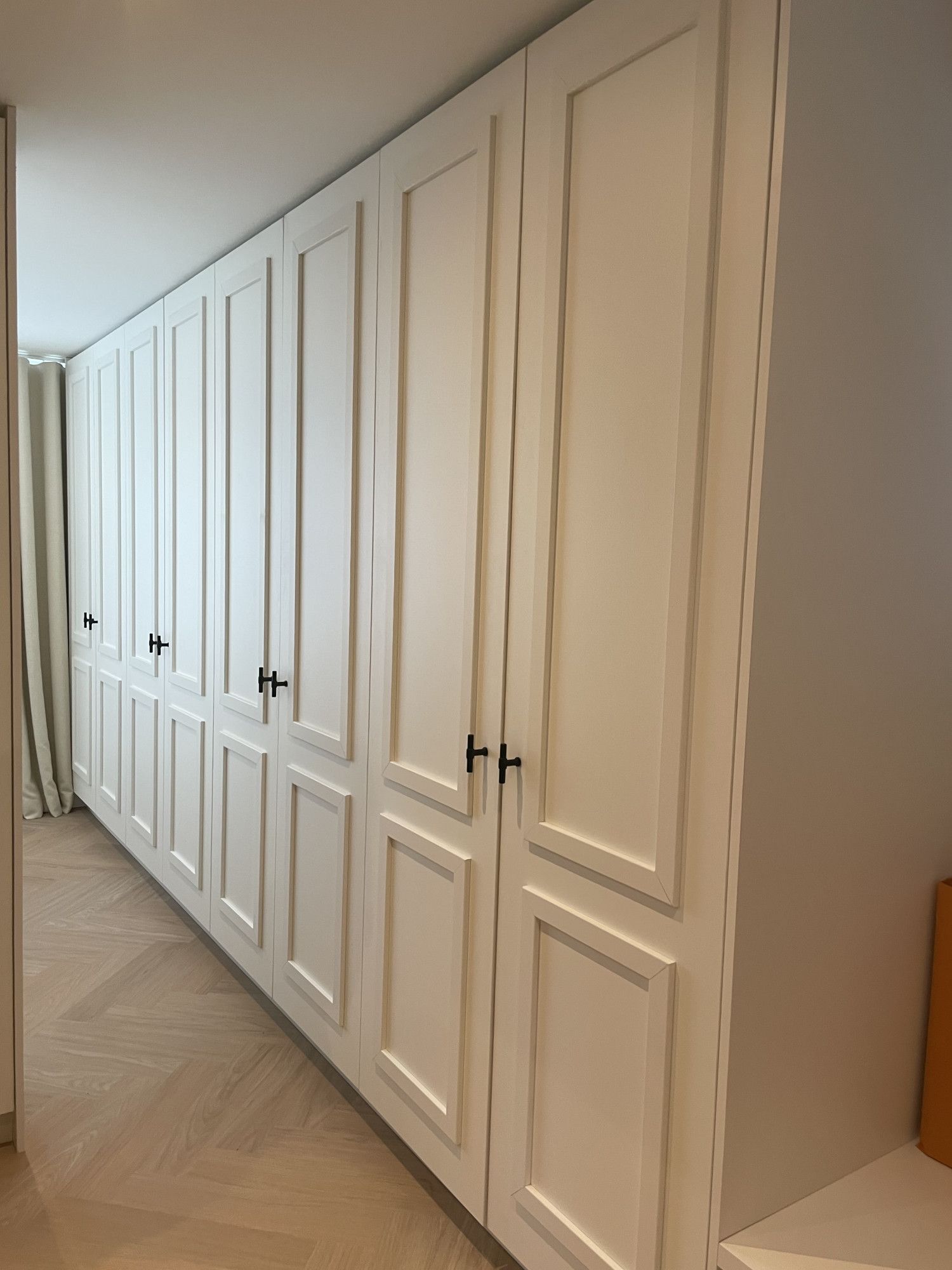 Witte klassieke kast met lijstwerk op de deuren